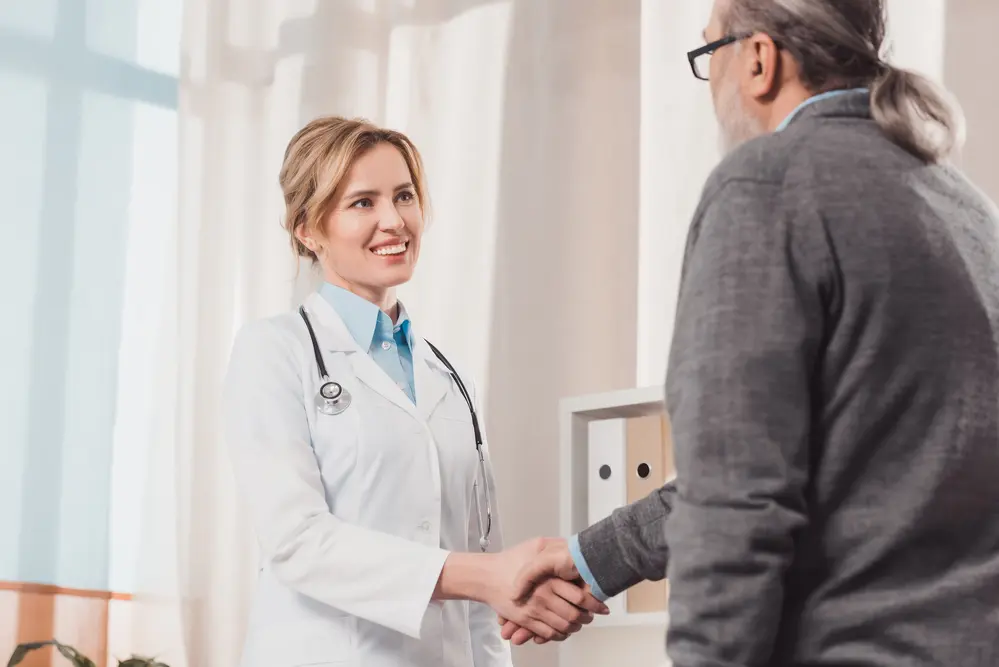 Smiling-female-doctor-shaking-hands-with-male-patient.jpg