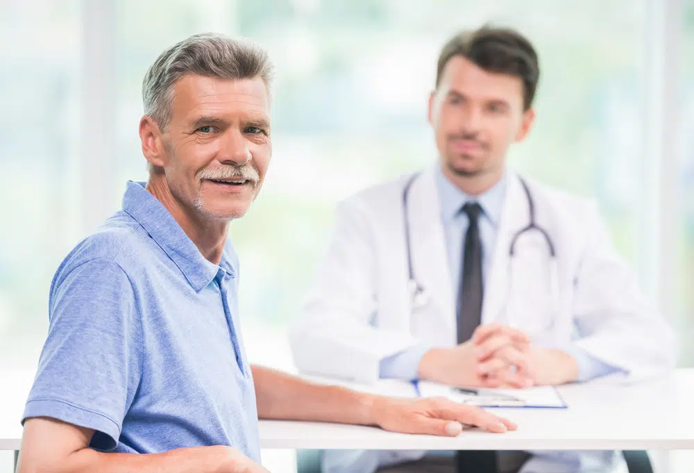 senior-man-sitting-across-from-young-doctor