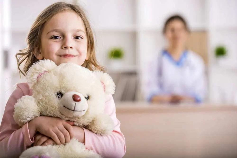 Smiling-young-girl-holding-teddy-bear