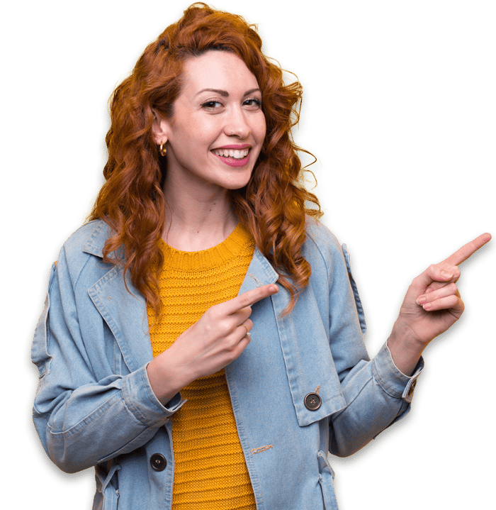 Happy red-headed woman in jean jacket pointing right